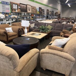 A furniture store with sofas, armchairs, coffee tables, and lamps arranged in a spacious showroom.