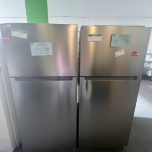 Two stainless steel refrigerators side by side with labels on the doors in a well-lit room.