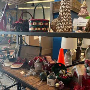 Shelves display assorted Christmas decorations, baskets, ornaments, festive trees, and holiday-themed items.
