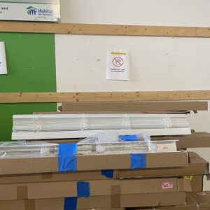 Stacked boxes and building materials with a no climbing sign on the wall behind them.