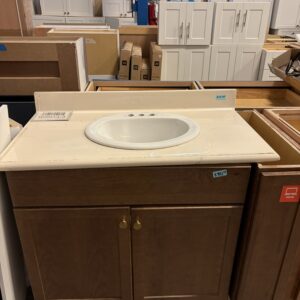 A bathroom vanity with a sink and wooden cabinet, displayed in a home improvement store.