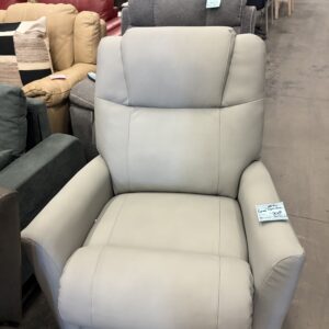 Light gray leather recliner chair on display in a furniture store, surrounded by other chairs and sofas.