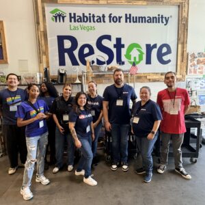 A group of volunteers pose and smile inside a Habitat for Humanity ReStore in Las Vegas.