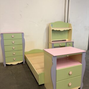 Pastel green, pink, and purple childrens furniture set: bed, nightstand, dresser, and shelf against a wall.