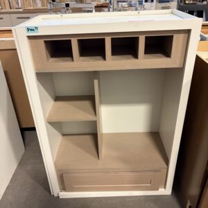 White wooden cabinet with cubby holes on top, open shelves, and a drawer at the bottom, in a store setting.