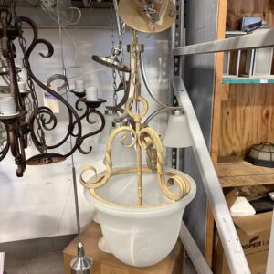 Large ornate pendant light fixture with frosted glass bowl on display in a store, surrounded by other lights.
