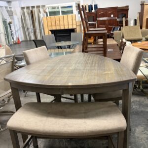 Hexagonal wooden table with two chairs and a bench in a furniture store showroom.