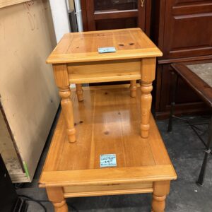 Two wooden end tables stacked, each with square tops, turned legs, and blue price tags on the surfaces.