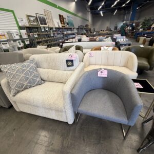 A furniture store displays sofas and chairs in various colors with price tags in a spacious showroom.