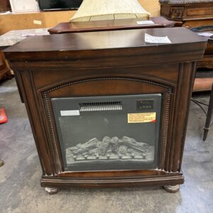 A dark wood electric fireplace with a glass front and decorative trim.
