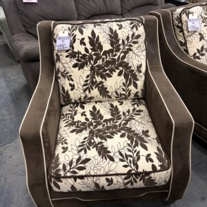 Armchair with brown velvet frame and off-white cushions featuring a brown leaf pattern.