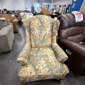 Wingback armchair with a floral pattern in a furniture warehouse.