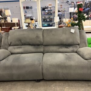 Gray two-cushion reclining sofa in a furniture store.