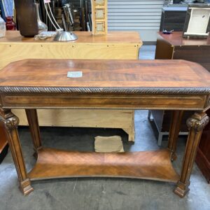A rectangular wooden console table with carved details and a lower shelf.