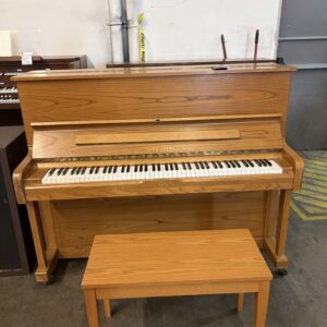 A wooden Young Chang upright piano with a matching bench.