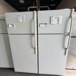 Two white top-freezer refrigerators with ReStore price tags and green tested stickers.